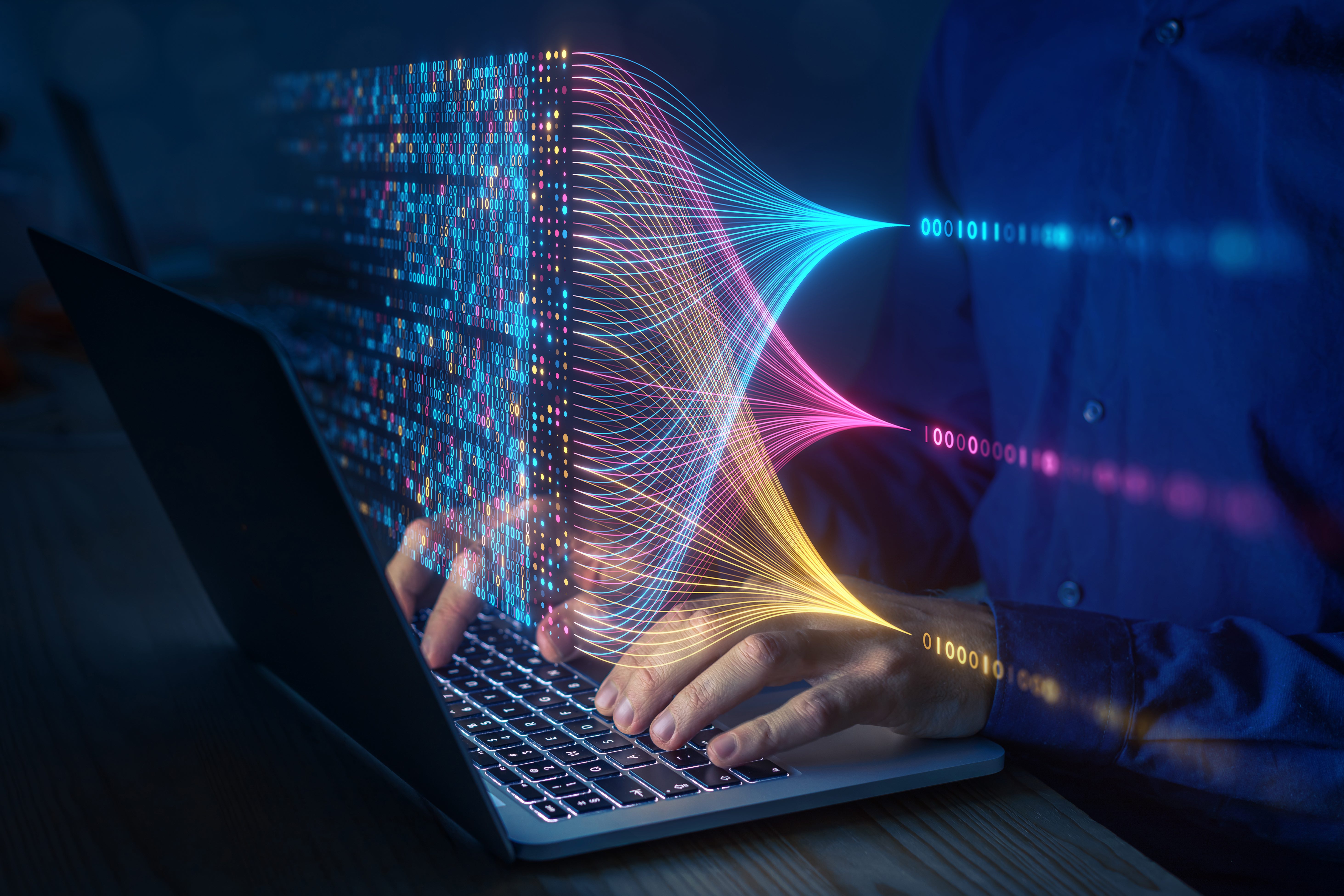 Stock image of a person using a computer to view binary code