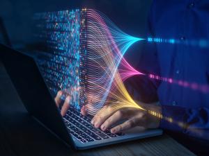Stock image of a person using a computer to view binary code