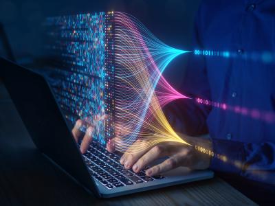 Stock image of a person using a computer to view binary code